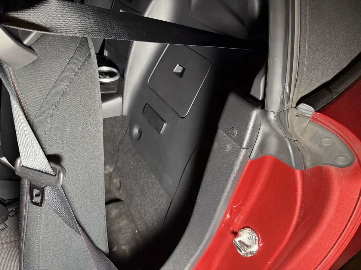 助手席の背もたれの後ろ。シートベルトの奥に ETC 車載器が見える